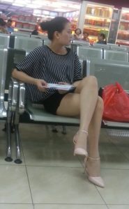 火车站坐在候车室的成熟女人在翘起腿时被抓拍