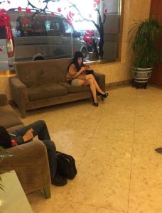 在酒店大堂坐着的一位时尚美女的恨天高美腿